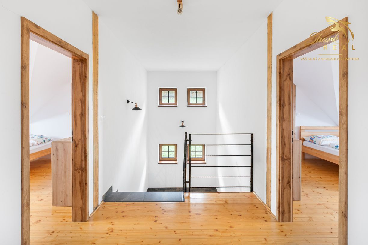 Krásna chata pod lesom s veľkým pozemkom.