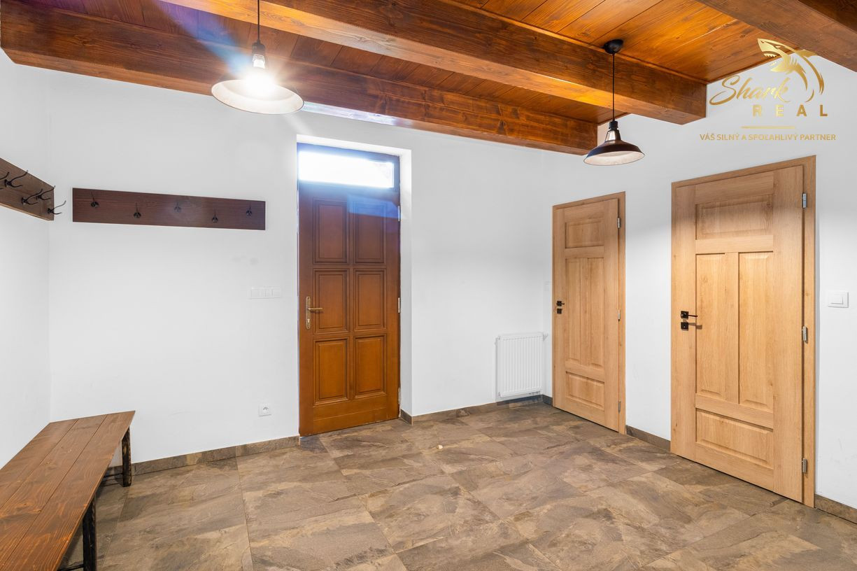 Krásna chata pod lesom s veľkým pozemkom.