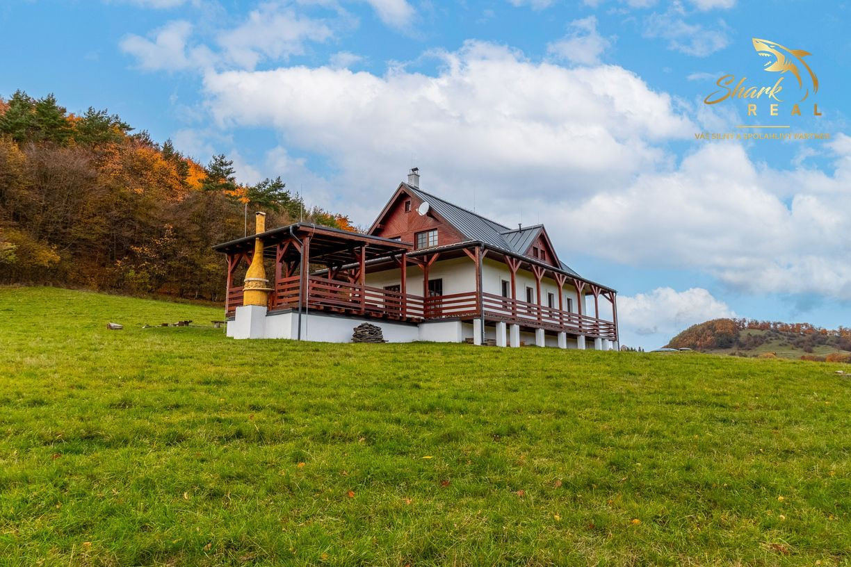 Krásna chata pod lesom s veľkým pozemkom.