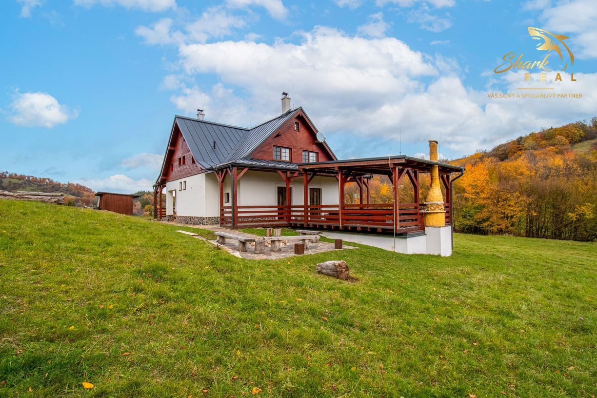 Krásna chata pod lesom s veľkým pozemkom.