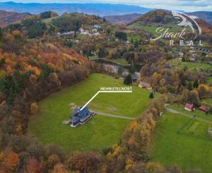 Krásna chata pod lesom s veľkým pozemkom.