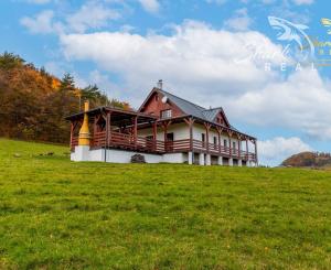 Krásna chata pod lesom s veľkým pozemkom.