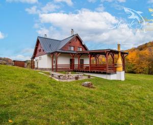 Krásna chata pod lesom s veľkým pozemkom.