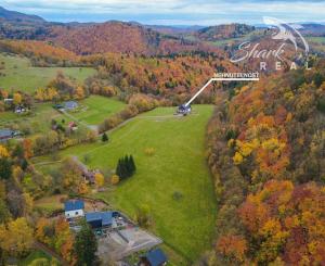 Krásna chata pod lesom s veľkým pozemkom.