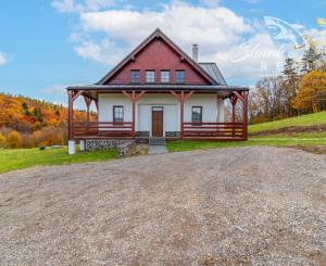 Krásna chata pod lesom s veľkým pozemkom.