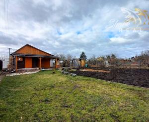 Pekná záhrada s chatkou, terasou a krbom na okraji mesta.