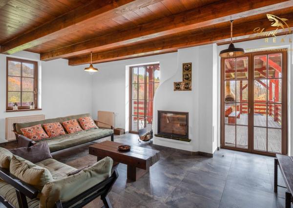 Krásna chata pod lesom s veľkým pozemkom.