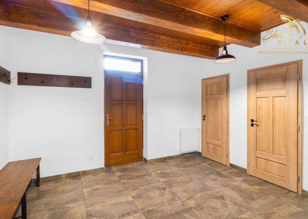 Krásna chata pod lesom s veľkým pozemkom.