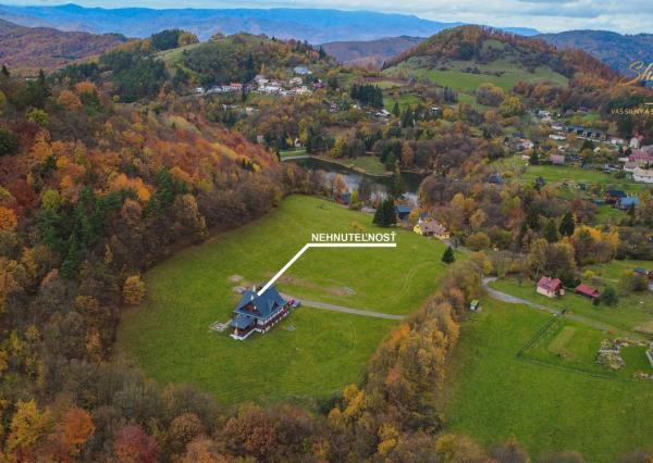 Krásna chata pod lesom s veľkým pozemkom.