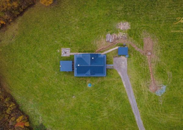 Krásna chata pod lesom s veľkým pozemkom.